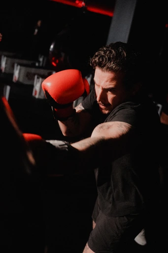 Close-up of a boxer hitting focus mitts held by a coach